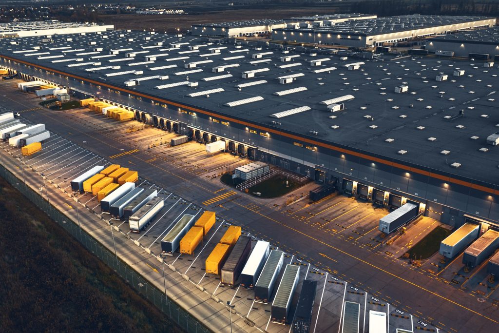 Vue aérienne d'une plateforme logistique et de ses quais de chargement au crépuscule
