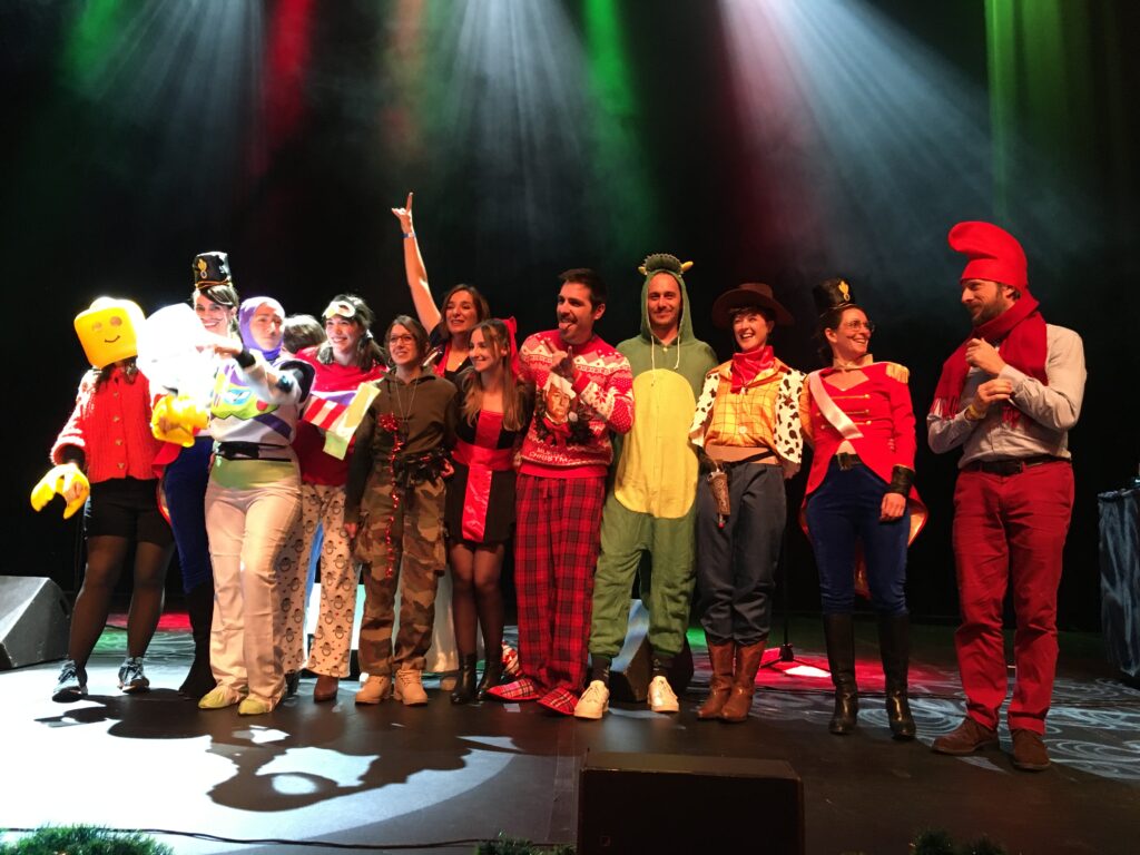 Collaborateurs costumés sur scène lors de la fête de Noël du CSE